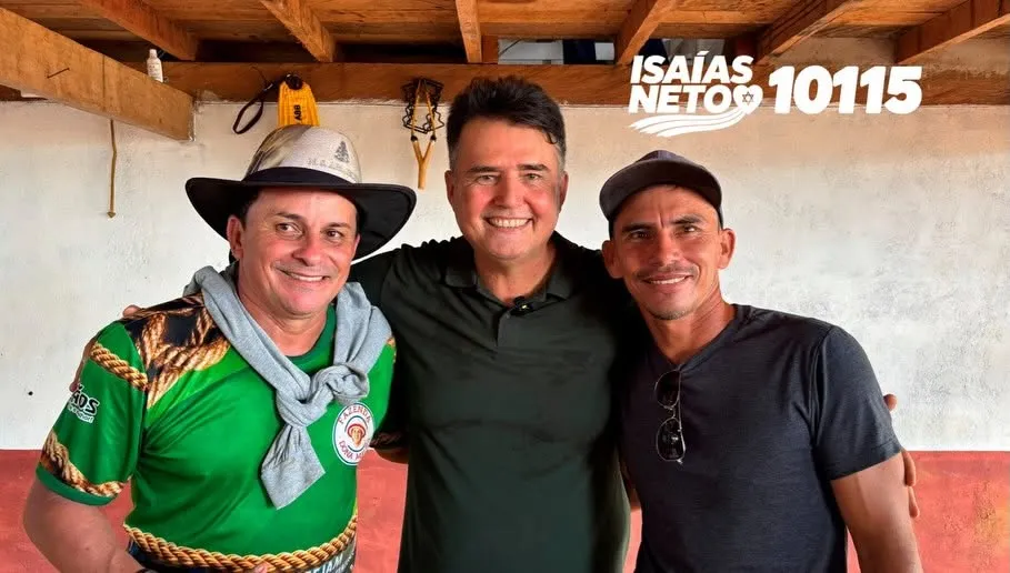 Isaías Neto entre dois apoiadores, um deles de chapéu de couro