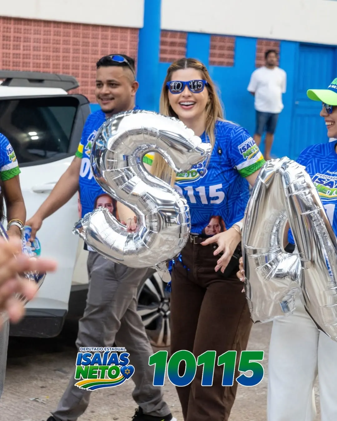 Equipe de campanha carregando balões prateados que formam o nome Isaías